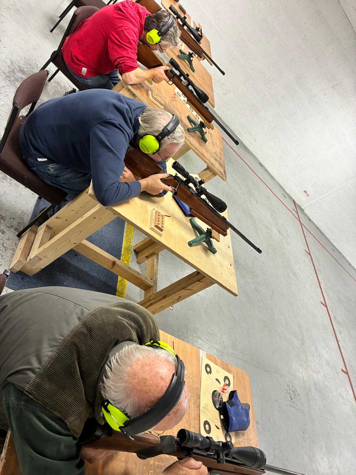 Guests shooting rifle from the benches wearing hearing protection.